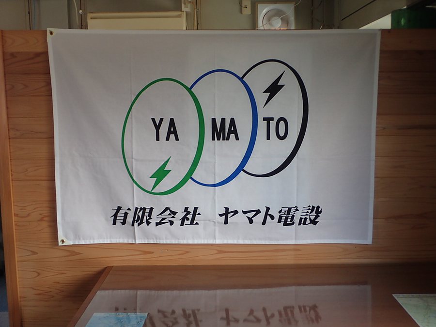 事務所に掲げられた有限会社ヤマト電設の社旗