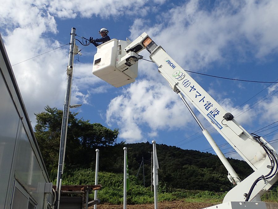 高所作業車のバケットから電柱の引込線を接続する作業