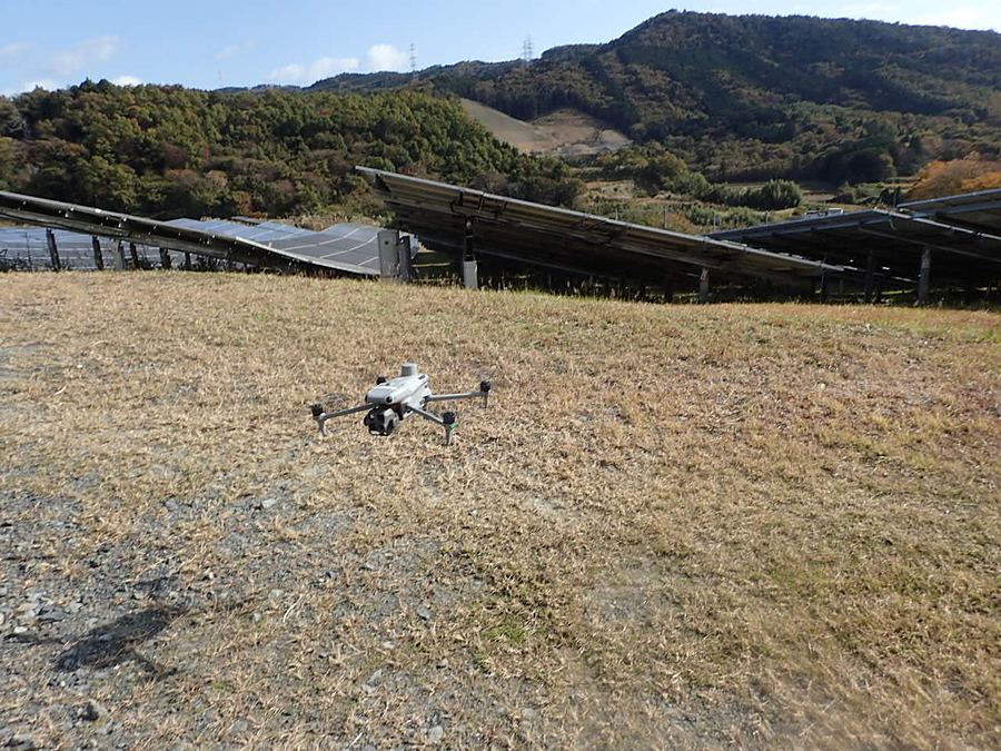 太陽光発電所の上空を飛行する点検用ドローン