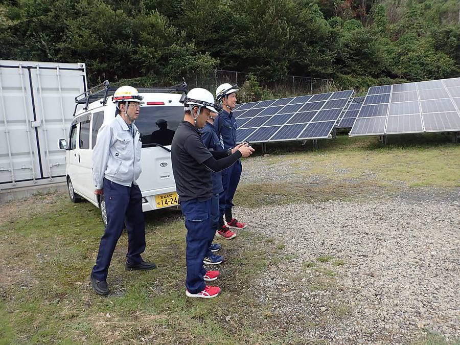発電所でドローンの飛行を複数人で監視する様子
